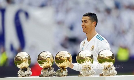 Cristiano Ronaldo berfoto 5 bola emas Ballon D'or miliknya di Stadion Santiago Bernabeu, Madrid, Sabtu (9/12) waktu setempat