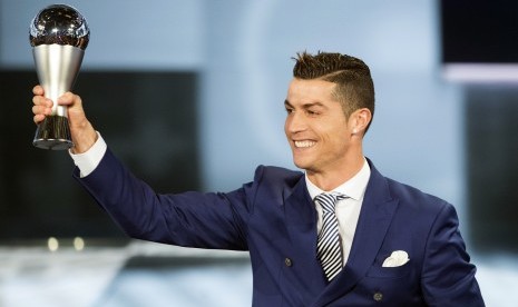 Cristiano Ronaldo mengangkat trofi pemain terbaik 2016 versi FIFA, Senin (9/1).