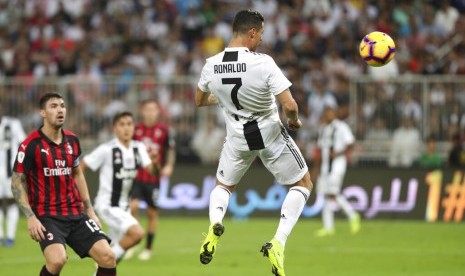 Crsitiano Ronaldo (kanan) saat hendak menanduk bola untuk menjebol gawang AC Milan pada laga Piala Super Italia.