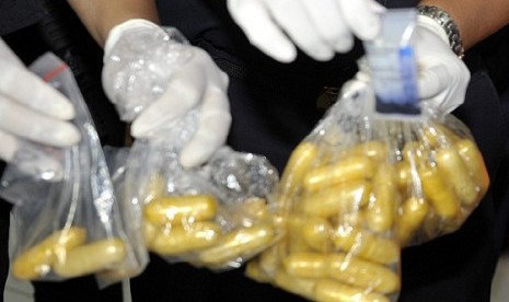 Custom officers shows capsules of methamphetamine (slank name: sabu-sabu -ed) seized from a Ugandan suspect in Ngurah Rai Airport, Bali, last week.  