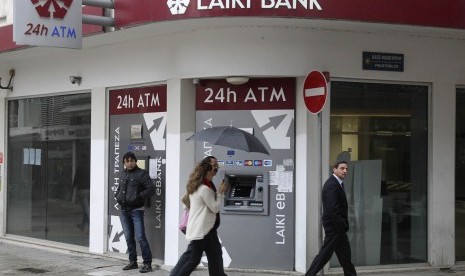 Cypriots walk pass a Cypriot bank on the island's capital Nicosia, April 18, 2013, as financial crisis shadows the future of of younger generation in Greece, Cyprus, Portugal, and Spain. (illustration)