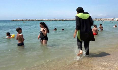 Dalam file foto 4 Agustus 2016 yang dibuat dari video, Nissrine Samali, 20, masuk ke laut mengenakan burkini, pakaian seperti pakaian selam yang juga menutupi kepala, di Marseille, Prancis selatan. Larangan Burkini Bukan Hanya Pengaruhi Wanita Muslim