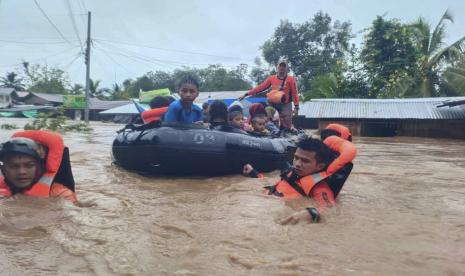 Dalam foto ini disediakan oleh Penjaga Pantai Filipina, penyelamat menggunakan perahu untuk mengevakuasi penduduk dari daerah banjir akibat Badai Tropis Nalgae di Parang, provinsi Maguindanao, Filipina selatan pada hari Jumat 28 Oktober 2022. Air banjir dengan cepat naik di banyak desa dataran rendah, memaksa beberapa penduduk desa untuk naik ke atap mereka, di mana mereka diselamatkan oleh pasukan tentara, polisi dan sukarelawan, kata para pejabat. 