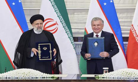 Dalam foto selebaran yang dirilis oleh Kementerian Luar Negeri Uzbekistan, Presiden Republik Uzbekistan Shavkat Mirziyoyev, kanan, dan Presiden Republik Islam Iran Ebrahim Raisi memegang dokumen yang ditandatangani selama pertemuan mereka di Pusat Kongres Samarkand pada malam Shanghai KTT Cooperation Organization (SCO) di Samarkand, Uzbekistan, Rabu, 14 September 2022.