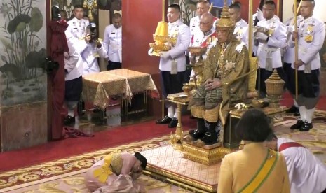 Dalam foto tangkapan video, Raja Thailand Maha Vajiralongkorn duduk di singgasana di depan Ratu Suthida saat secara resmi dinyatakan sebagai raja di Grand Palace, Bangkok, Sabtu (4/5).