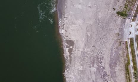 Dalam foto udara ini, tepian Sungai Jialing yang lebih rendah dari biasanya terlihat di Kota Chongqing, China barat daya, Jumat, 19 Agustus 2022. Kapal-kapal merayap di tengah Sungai Yangtze pada hari Jumat setelah musim panas terkering dalam enam dekade meninggalkan salah satu dari sungai-sungai terkuat menyusut menjadi hampir setengah dari lebar normalnya dan memicu perebutan untuk menahan kerusakan pada ekonomi yang lemah di tahun yang sensitif secara politik.