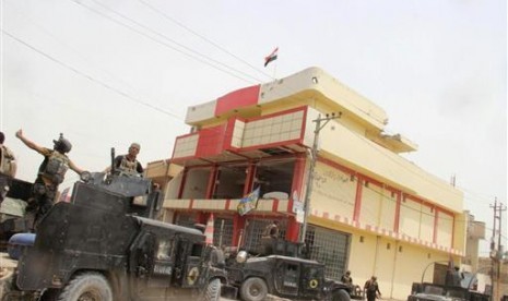 Dalam foto yang diambil fotografer dari Badan Antiterorisme Irak, Ahad, 19 Juni 2016 ini menunjukkan bendera Irak berkibar di Fallujah. Pasukan Irak merebut kota tersebut setelah dua tahun dikuasai ISIS.