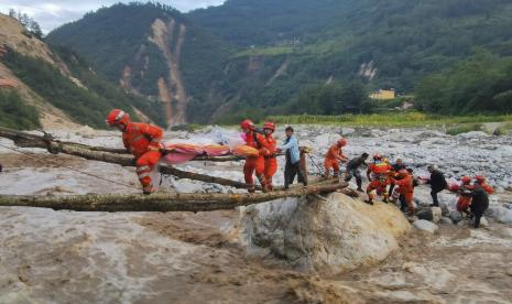 Dalam foto yang dirilis oleh Kantor Berita Xinhua, tim penyelamat memindahkan korban melintasi sungai setelah gempa bumi di Kota Moxi, Kabupaten Luding, Provinsi Sichuan, China barat daya, Senin, 5 September 2022. Puluhan orang dilaporkan tewas dan hilang dalam gempa yang mengguncang China. provinsi barat daya Sichuan pada hari Senin, memicu tanah longsor dan mengguncang bangunan di ibu kota provinsi Chengdu, yang 21 juta penduduknya sudah berada di bawah penguncian COVID-19.