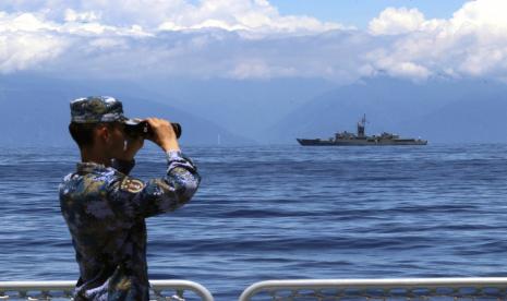  Dalam foto yang disediakan oleh Kantor Berita Xinhua China ini, seorang anggota Tentara Pembebasan Rakyat melihat melalui teropong selama latihan militer saat fregat Taiwan Lan Yang terlihat di belakang, pada hari Jumat, 5 Agustus 2022. Amerika Serikat (AS) dan Taiwan pada Rabu (17/8/2022) sepakat untuk memulai pembicaraan perdagangan di bawah inisiatif baru.