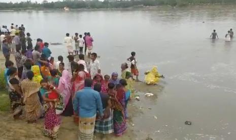 Dalam gambar yang diambil dari video ini, orang-orang melakukan operasi pencarian di Sungai Karatoa di mana sebuah perahu yang penuh sesak terbalik, di Panchagarh, Bangladesh Minggu, 25 September 2022. Sebuah perahu yang membawa sekitar 100 peziarah Hindu terbalik pada hari Minggu di sungai di Bangladesh utara, kata polisi.