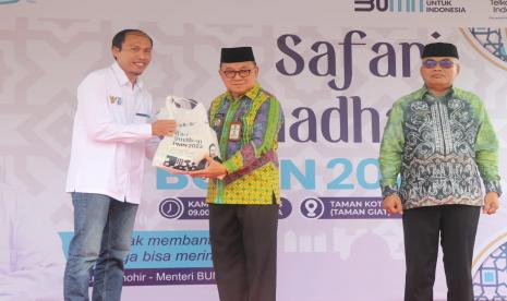 Bupati Tabalong Anang Syakhfiani (tengah) secara simbolis mewakili masyarakat menerima paket sembako murah yang diserahkan oleh Kepala Kantor Daerah Telkom Tanjung Tabalong Pamuji Santasa (paling kiri) dalam kegiatan Safari Ramadhan BUMN 2023, pada Kamis (13/4/2023).