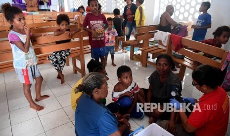 Dampak Banjir Bandang Sentani. Anggota Basarnas bersama petugas kesehatan memeriksa kondisi warga yang mengungsi akibat banjir bandang Sentani di sekitar Danau Sentani, Sentani, Jayapura, Papua, Selasa (19/3/2019).