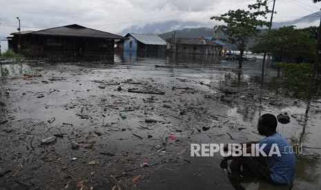 Dampak Banjir Bandang Sentani. Seorang warga mengamati permukiman tempat tinggalnya yang terendam banjir bandang di sekitar Danau Sentani di Jayapura, Papua, Selasa (19/3/2019). 