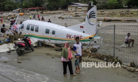 Dampak Banjir Bandang Sentani. Warga berada di dekat pesawat udara yang terdampak banjir bandang di Sentani, Kabupaten Jayapura, Papua, Ahad (17/3/2019).