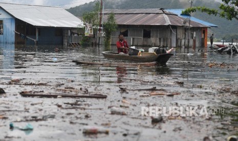 Dampak Banjir Bandang Sentani. Warga mengamankan barang berharga miliknya dari rumahnya yang terendam banjir bandang di kawasan Danau Sentani, Sentani, Jayapura, Papua, Selasa (19/3/2019). 