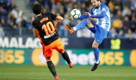 Daniel Parejo berebut bola dengan pemain Malaga Manuel Ittura (kanan). 