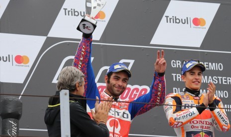 Danilo Petrucci (tengah) dan Marc Marquez di podium MotoGP di Misano, San Marino, Ahad (10/9).