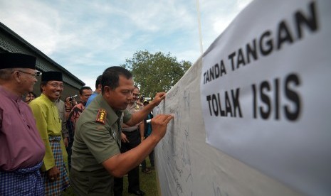 Danrem 042/Gapu Jambi Kolonel Inf Harianto (kanan) didampingi sejumlah tokoh membubuhkan tanda tangan menolak paham ISIS usai Deklarasi Penolakan Paham ISIS di lapangan Korem 042/Gapu, Jambi, Selasa (31/3).