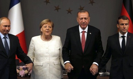  Dari kiri, Presiden Rusia Vladimir Putin, Kanselir Jerman Angela Merkel, Presiden Turki Recep Tayyip Erdogan, dan Presiden Prancis Emmanuel Macron berpose di akhir konferensi pers setelah pertemuan puncak KTT Suriah, di Istanbul, Turki, Sabtu (27/10).