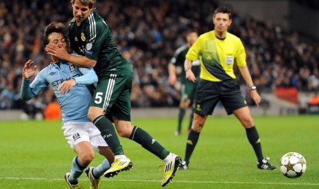 David Silva dihadang Fabio Contreao dalam lanjutan Liga Champions Kamis (22/11) dini hari. City tidak lolos ke 16 besar setelah ditahan imbang Madrid 1-1