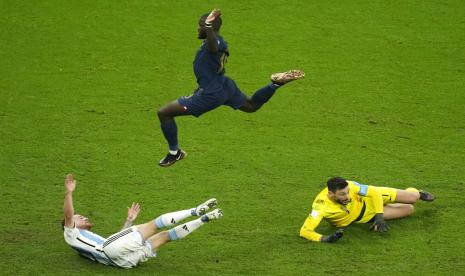 Dayot Upamecano dari Prancis (atas) melompati kiper Prancis Hugo Lloris (kanan) dan Alexis Mac Allister dari Argentina (kiri) selama pertandingan sepak bola final Piala Dunia antara Argentina dan Prancis di Stadion Lusail di Lusail, Qatar, Ahad (18/12/2022).