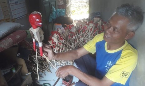 Dede yang akrab disapa Dede Wayang tengah memproduksi wayang mainan cepot dan yang lainnya di rumahnya di Kampung Babakan Garut, Desa Mekarsari, Kabupaten Bandung Barat, Rabu (12/5).