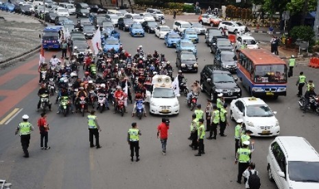 Demo pemotor tolak pelarangan sepeda motor melewati Jalan MH Thamrin di Bundaran HI, Jakarta, Senin (22/12). 