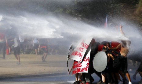 Demonstran antipemerintah disemprot water cannon oleh polisi di Santiago, Cile, Jumat (15/11).