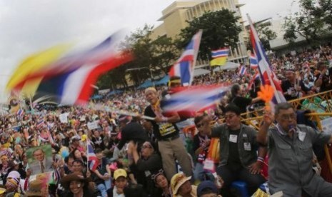 Demonstran antipemerintah melambaikan bendera Thailand, menuntut PM Yingluck Shinawatra mundur dari jabatannya.