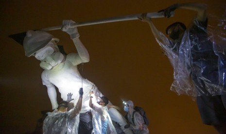 Demonstran antipemerintah mendirikan patung Lady Liberty setinggi empat meter di puncuk pegunungan Lion Rock, Ahad pagi (13/10).