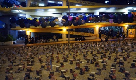 Demonstran berkumpul di kampus Hong Kong Baptist University yang dipenuhi payung dan jalanan diberi blokade tumpukan batu bata di Hong Kong, Rabu (13/11).