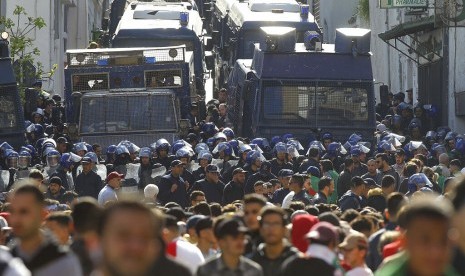 Demonstran dan polisi antihuru-hara dalam protes menuntut lengsernya Presiden Aljazair Abdelaziz Bouteflika di Aljir, Aljazair, 29 Maret 2019. 