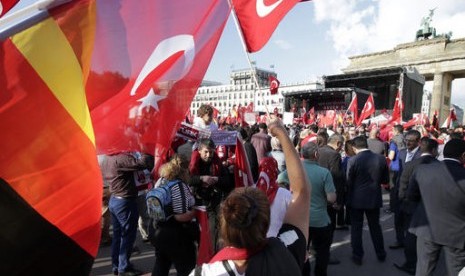 Demonstran melambaikan bendera Turki dan Jerman di depan gerbang Brandenburgdi Berlin, Jerman, Rabu, 1 Juni 2016. Mereka menentang resolusi yang mengakui genosida Armenia oleh Ottoman Turki.