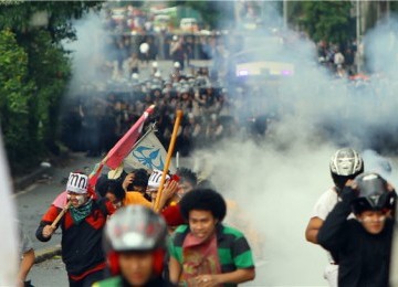 Demonstran melarikan diri saat polisi menembakkan gas air mata ketika melakukan aksi demonstrasi menolak kenaikan harga BBM di depan gedung DPR/MPR, Senayan, Jakarta. 