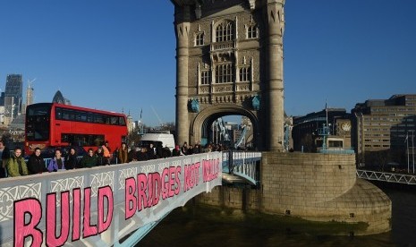 Demonstran memasang banner bertuliskan 'Build Bridges not Walls' di Tower Bridge London, Inggris, dalam aksi protes terhadap pelantikan Donald Trump. 