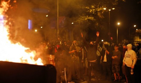 Demonstran membakar barikade di Barcelona, Spanyol, Sabtu (19/10). Demonstran memprotes sembilan pemimpin separatis yang dipenjara.