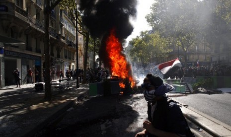 Demonstran membakar barikade saat demonstrasi perubahan iklim di Paris, Sabtu (21/9)