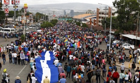 Demonstran membawa bendera Honduras saat melakukan aksi protes menuntut Presiden Juan Orlando Hernandez mundur di Tegucigalpa, Honduras, Selasa (6/8).