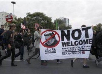 Demonstran membawa spanduk menentang kunjungan Paus Benediktus XVI ke Jerman, dalam sebuah unjuk rasa di Berlin, 21 September 2011