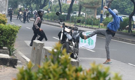 Demonstran menendang motor polisi saat kericuhan yang terjadi pada unjuk rasa di depan Gedung KPK, Jakarta, Jumat (20/5). (Antara/Hafidz Mubarak A)