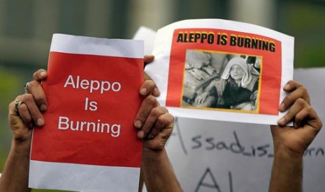 Demonstran mengacungkan poster saat berunjuk rasa di depan Markas PBB di Beirut, Lebanon, Ahad, 1 Mei 2016. Mereka menentang operasi militer di wilayah yang dikuasai pemberontak, dengan Aleppo menjadi pusatnya.