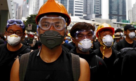 Demonstran mengenakan kacamata pelindung dan masker berjalan menuju Dewan legislatif untuk melanjutkan protes menentang RUU ekstradisi di Hong Kong, Senin (17/6).