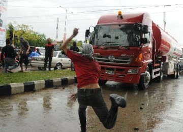 Demonstran merusak truk pengangkut BBM Pertamina saat menggelar unjuk rasa menolak rencana pemerintah menaikkan harga Bahan Bakar Minyak (BBM) per 1 April. 