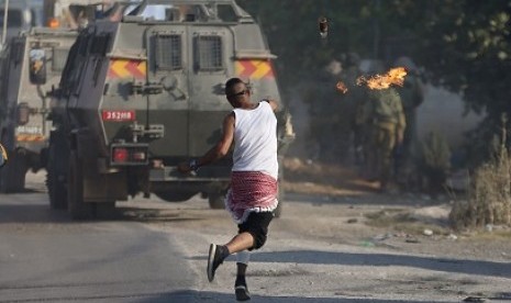 Demonstran Palestina melempar bom molotov ke militer Israel. 