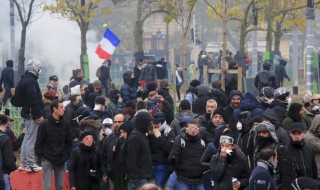 Demonstran rompi kuning dalam peringatan pertama gerakan tersebut di Paris, Sabtu (16/11). Protes rompi kuning berujung bentrok dengan polisi.