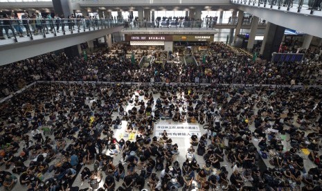 Demonstran saat melakukan aksi duduk di terminal kedatangan di Bandara Internasional Hong Kong, Hong Kong, Senin (12/8). Semua penerbangan yang tersisa dibatalkan. 