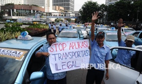 Demonstran tergabung dalam Paguyuban Pengemudi Angkutan Darat (PPAD) melakukan aksi unjukrasa saat melintas di Bundaran HI, Jakarta, Selasa (22/3).