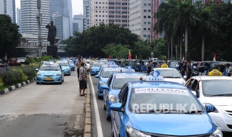 Demonstran tergabung dalam Paguyuban Pengemudi Angkutan Darat (PPAD) melakukan aksi unjukrasa saat konvoi melintasi Jl Sudirman, Jakarta, Selasa (22/3). 