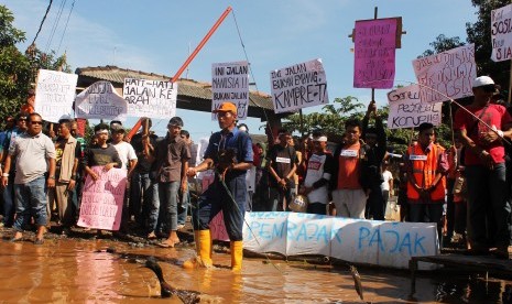 Demonstrasi warga menuntut perbaikan jalan rusak.