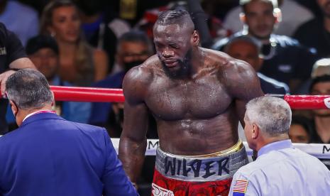 Deontay Wilder dari AS (tengah) diperiksa oleh ofisial ring selama pertarungannya melawan Tyson Fury dari Inggris selama pertarungan gelar juara dunia kelas berat WBC 12 ronde di T-Mobile Arena di Las Vegas, Nevada, AS, 09 Oktober 2021.